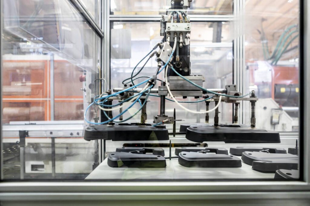 Pinza robotizzata che preleva i pezzi dalla pressa a iniezione