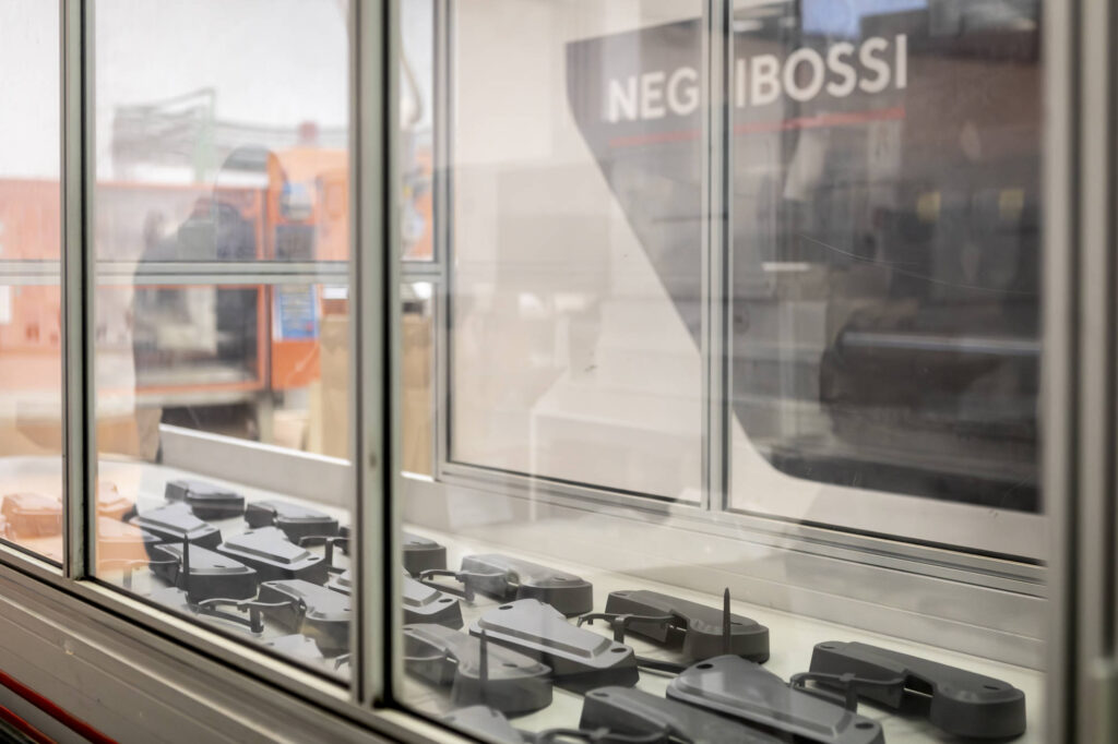 Pressa a iniezione Negri Bossi con i pezzi stampati