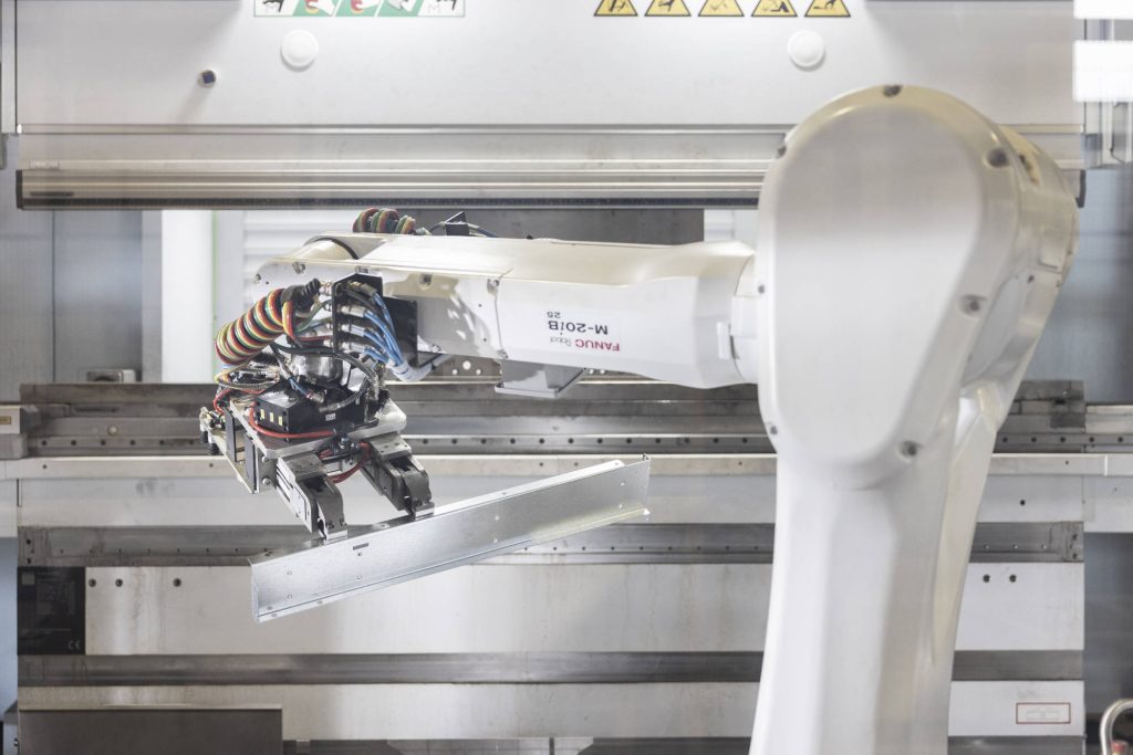 Robot che sposta un profilo in lamiera appena piegato