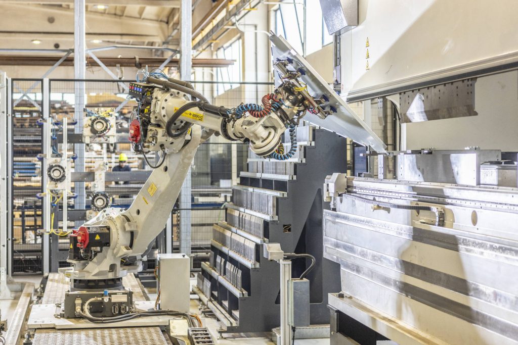 Cella di piegatura robotizzata con robot su binario e magazzino utensili