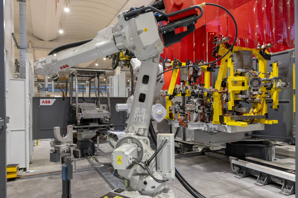Robot ABB accanto all'attrezzatura di saldatura di un telaio